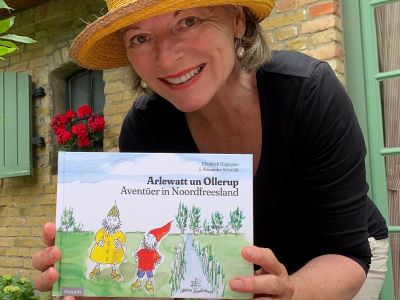 Autorin Elisabeth Hagopian zeigt die plattdeutsche Ausgabe von Arlewatt und Olderup.