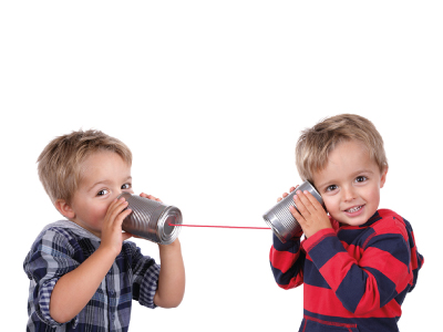 zwei Kinder probieren ein Dosentelefon aus