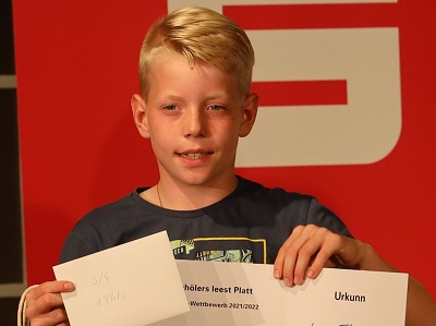 Luca Thomsen zeigt seine Urkunde als Sieger bei "Schölers leest Platt"