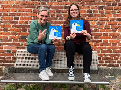 zwei Frauen präsebtieren das Programmheft der plattdüütsche Week 2026